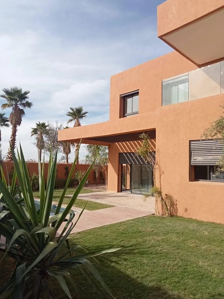 Façade ocre de la villa à Marrakech vue depuis le jardin
