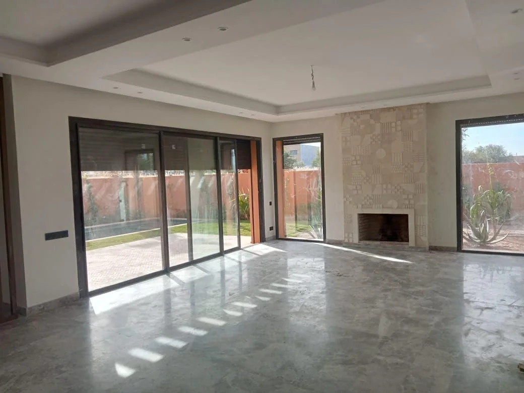 Volume intérieur lumineux avec baies vitrées et cheminée dans la villa à Marrakech